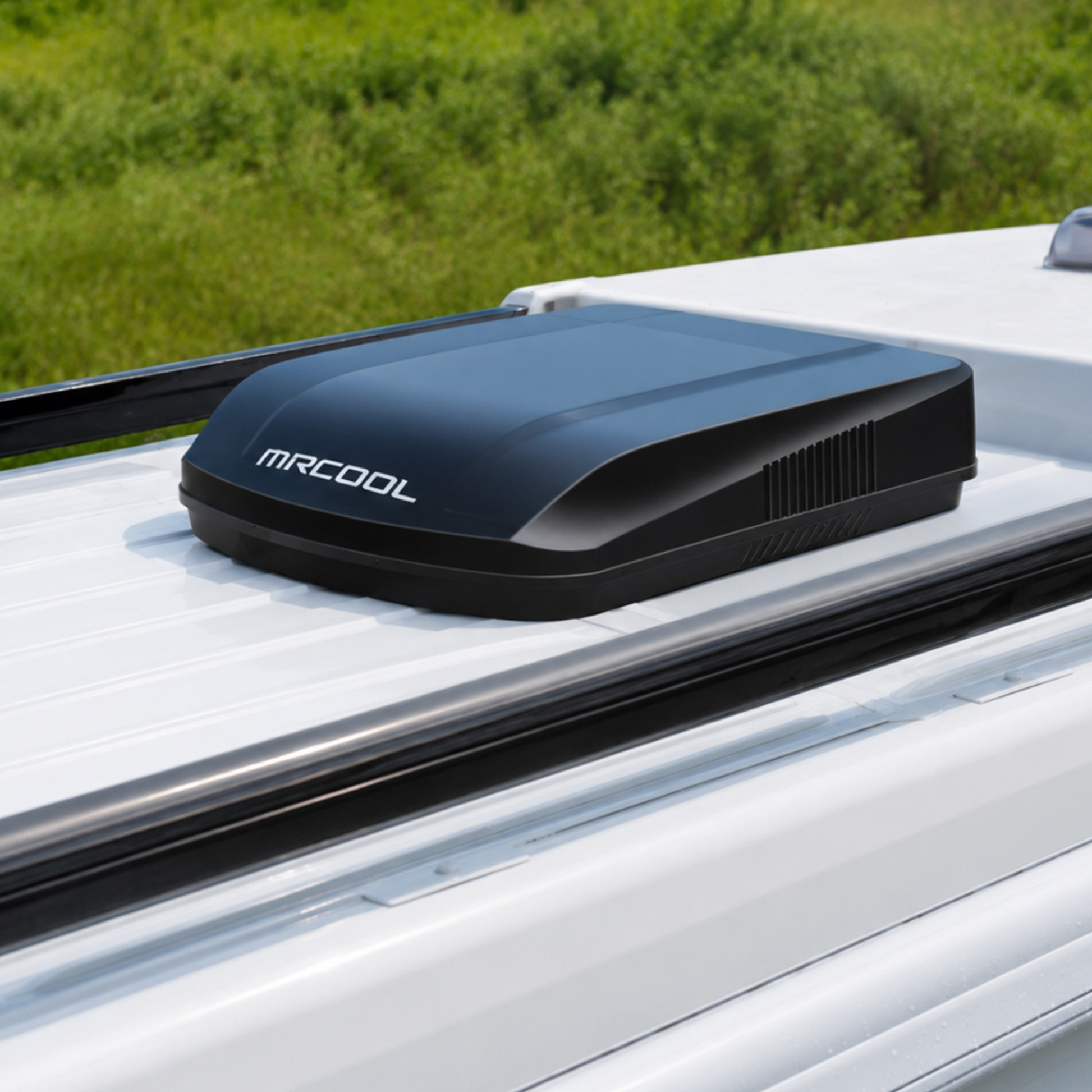 MRCOOL® TravelCool™ 15,000 BTU black RV inverter heat pump installed on the roof of a travel trailer, featuring a low-profile aerodynamic design, variable-speed inverter technology, 115V power, WiFi connectivity, R-32 refrigerant, and quiet heating and cooling performance, Model MRDHP15K-D.